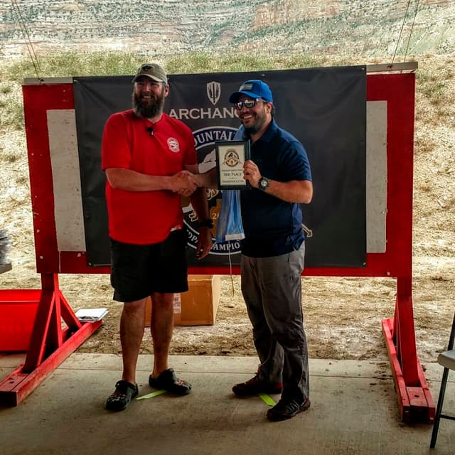 Alumno coacheado por Jorge Chaves recibiendo un premio en un torneo internacional en Estados Unidos, demostrando el éxito del coaching de tiro deportivo.