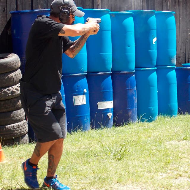 Alumno de TDU disparando pistola en posición CAR durante un ejercicio del curso de tiro defensivo.