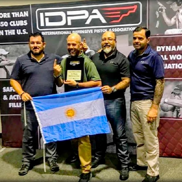 Equipo argentino de IDPA dirigido por Jorge Chaves, celebrando con la bandera nacional en el Campeonato Nacional de Estados Unidos en Alabama.