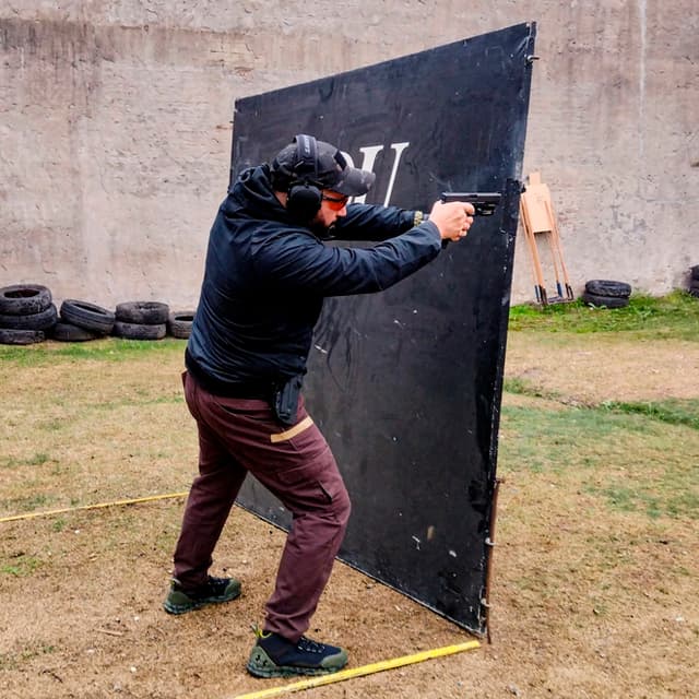 Alumno practicando el uso de cobertura y tiro desde barricada con pistola en el curso de tiro dinámico de TDU.