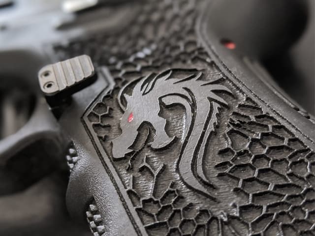 Empuñadura de Glock 34 con diseño personalizado grabado en láser por TDU Custom, combinando estética exclusiva con un agarre técnico superior.