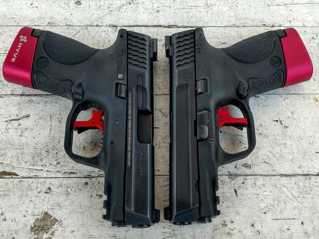 Par de pistolas Smith & Wesson M&P con gatillos de alto rendimiento color rojo, instalados y ajustados por TDU Custom para un reset más corto.